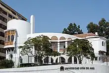 A white, rounded building with red Spanish tile roof