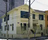 Photograph of a yellow house on a street corner