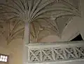 Stone staircase with central column and palm tree vaulting.