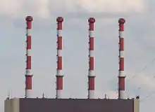 Close-up view of four red and white chimneys.