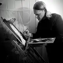 Artist painting at easel