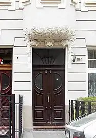 Gate decoration with leaves and the head of a woman