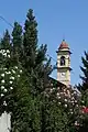 The bell tower of San Martino in Balsamo, behind the oleanders of the Pius XI Oratory.