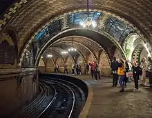 The station as seen from the rear of the platform. The lights are powered on, and there are visitors standing on the platform.