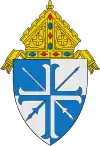 The arms of the Diocese of Lansing: The lances crossed per saltire are a play on the name of the see, the city of Lansing, Michigan.