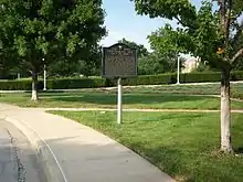 Metal plaque along a roadside, with the heading "Tour Stop E: Confederate line"