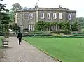 Large house with terrace and lawn.