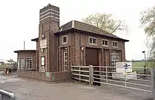 Brick building with large door and chimney.