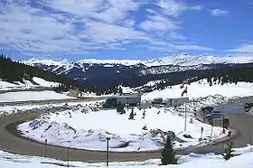 A parking lot with a view of several snow-capped mountains