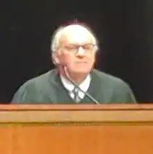 Justice Hill sitting at a dais