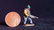 Miniature figure painted by Duncan Probert. The figure is slightly taller than an English penny and is in the style of a starship trouper on patrol.