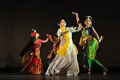 Four women wearing saree in different dancing poses.