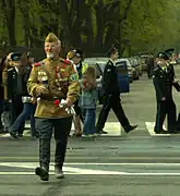 A man dressed as a veteran of the Great Patriotic War wearing both a gymnastyorka and a pilotka.