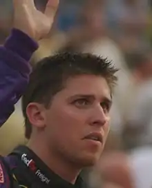 NASCAR driver Denny Hamlin waves to fans before a race.