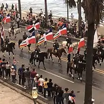 Dominican Army marching on Dominican Independence Day with flags.