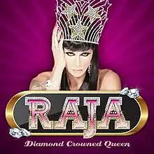 An image of a drag queen wearing an ornate crown and posing against a purple background. It has the words "Raja" and "Diamond Crowned Queen" in the center.