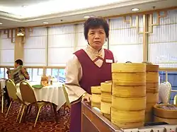 A server pushes a cart laden with bamboo baskets