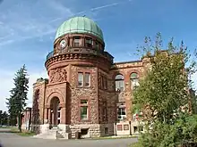 The Dominion Observatory building in Ottawa. A Romanesque Revival stone building with a prominent green dome.