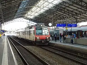 White train with red front under curved train shed