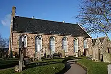 The front face of a small church with a small graveyard situated in front of it