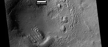 Layered structure in crater that is probably what is left of a layered unit that once covered a much larger area.  Material for this unit fell from the sky as ice-coated dust.  The picture was taken by HiRISE, under the HiWish program. Picture is from Hellas quadrangle.