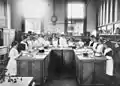 Cookery class about 1910 at the Echuca Mechanics' Institute, Victoria. The motto reads "Our Motto: Instead of being regarded as a servile employment, Cookery here is exalted into a science".