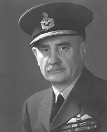 A black and white, head and shoulders portrait of a man in military uniform