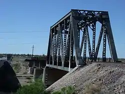 The historic Agua Fria River Bridge was built by the Santa Fe Railroad over the Agua Fria River in 1895. It is located on the right side of Grand Avenue traveling from Phoenix to Wickenburg, close to 111th Ave. in El Mirage.