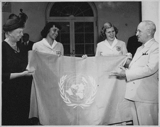 three women and a man hold up a flag