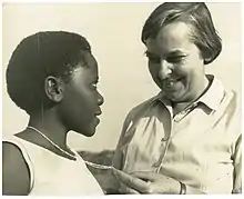 Elizabeth Reid, Grail Journalist and community development worker, admires a cross worn by a student at the Maryknoll school in Mwanza, Tanganyika.