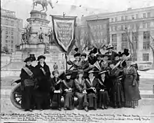 Equal Suffrage League of Richmond, Va. in front of Washington Monument, Capitol Square, Richmond. The members of the ESL were promoting the suffrage film, "Your Girl and Mine.", February 1915