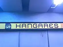 Picture of a wall sign featuring Hangares logo, a biplane inside a hangar.