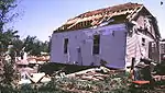 F1 tornadoes cause major damage to mobile homes and automobiles and can cause minor structural damage to well-constructed homes. This frame home sustained major roof damage, but otherwise remained intact.