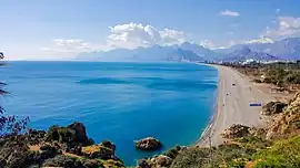 Konyaaltı Beach as seen from the nearby cliffs. The Beydağları mountains can be seen in the background.