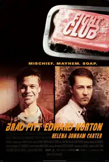 "FIGHT CLUB" is embossed on a pink bar of soap in the upper right. Below are head-and-shoulders portraits of Brad Pitt facing the viewer with a broad smile and wearing a red leather jacket over a decorative blue t-shirt, and Edward Norton in a white button-up shirt with a tie and the top button loosened. Norton's body faces right and his head faces the viewer with little expression. Below the portraits are the two actors' names, followed by "HELENA BONHAM CARTER" in smaller print. Above the portraits is "MISCHIEF. MAYHEM. SOAP."