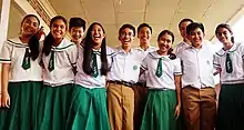 Ten students stand together.  All are wearing their school uniforms.