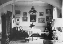 Living-dining room with arched entrance and many pictures on the wall