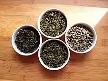 Four small white bowls of tea