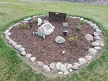 A ring of rocks surrounds memorial plaques