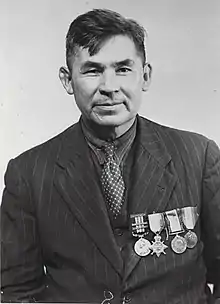 older man with suit, tie, and medals on his chest