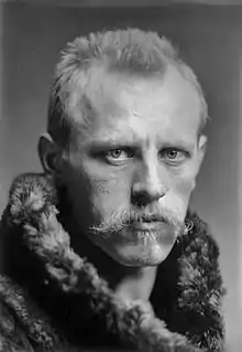  Head of a man with a determined expression, blond hair and moustache, looking straight to the camera