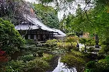 The outside of the temple's main hall with a nearby pond