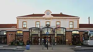 Two-story building with hipped roof and single-story wings