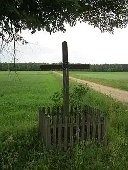 The cross is currently located on the district road of Średnio Pawłowięta - Dąbrówka Kościelna. In front of this cross, there is a dirt road that led to the headquarters of the Stare Gierałty 134 estate.