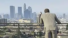 The player character with their back to the camera, and the sprawl of an urban city centre in front of them.