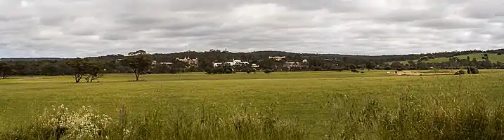 View from a hill over looking the green fields across to the town of New Norcia with all of the historic building within the image