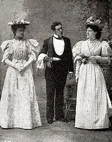 Butler standing between two young women