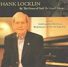 Hank Locklin sitting next to a piano wearing a black blazer with a white shirt underneath. There is a black bar with the name of the artist and album title written in yellow text at the top of the album cover. There is also a church in the right corner of this bar. Next to Hank Locklin is text that reads: Featuring Gold City, Jeff & Sheri Easter, The Jordaniares & The Oak Wood Boys.