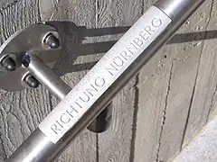 Haptic information in normal writing and Braille on the railing.