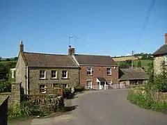 Two-storey stone houses with a road in front.